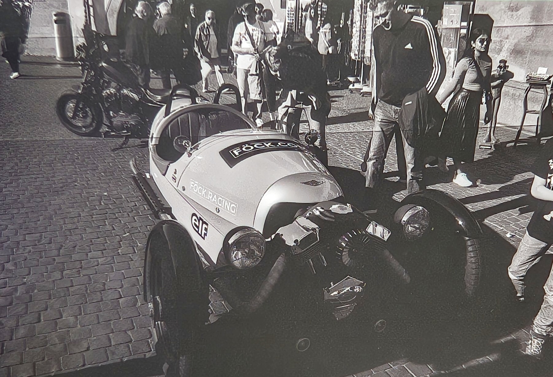 An old roadster car in Zurich, surrounded by fascinated people